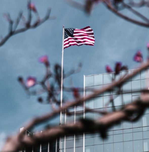 an American flag flying next to a corporate building