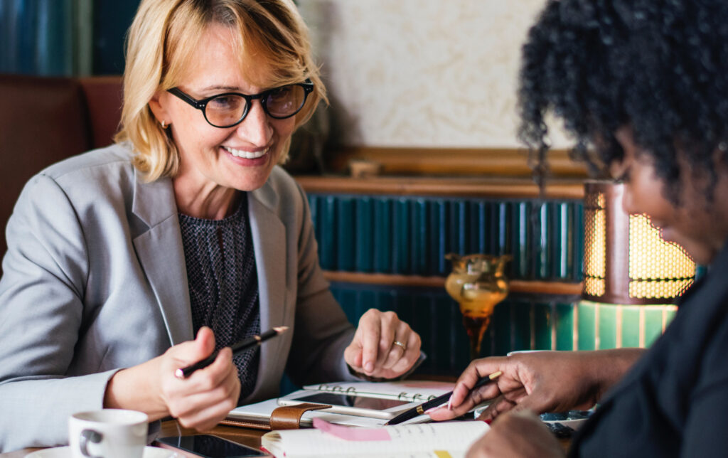 two businesswomen talking over coffee