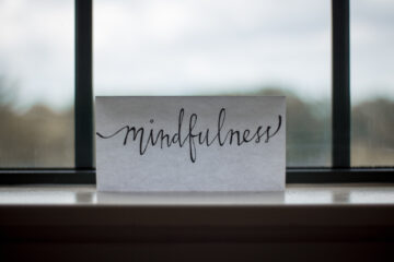 a note on a windowsill that says "mindfulness" in handwriting